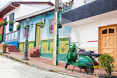 Green motorcycle at the colorful town of Guatape, Antioquia Stock Photo